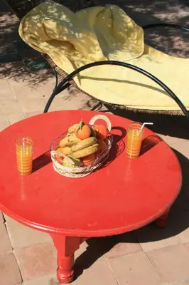 a red table with a bowl of fruit on it at kasbah 123 soleil in Skoura
