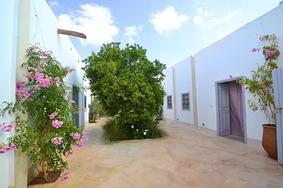 a courtyard with pink flowers and white buildings at La Villa douce in Marrakech