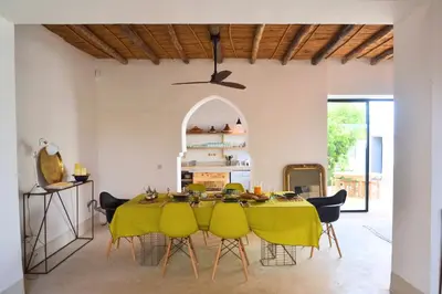 a dining room with a table and yellow chairs at La Villa douce in Marrakech
