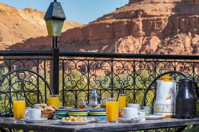 a table with plates of food and drinks on a fence at Hotel Awayou in Bou Tharar