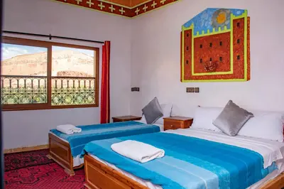 a bedroom with two beds and a window at Hotel Awayou in Bou Tharar
