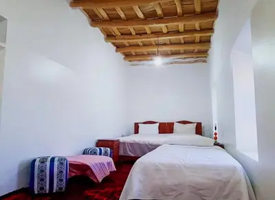 a bedroom with two beds and a wooden ceiling at ZEN ECOLODGE in Tighli