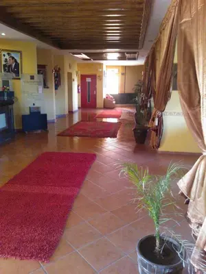 a lobby with red rugs on the floor of a building at HOTEL CONTINENTAL Khénifra in Khenifra