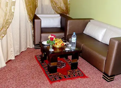 a living room with a brown couch and a table at HOTEL CONTINENTAL Khénifra in Khenifra