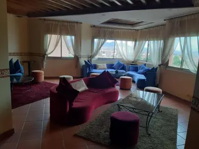 a living room with a red couch and blue couches at HOTEL CONTINENTAL Khénifra in Khenifra