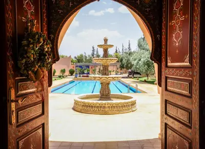 a fountain in the middle of a courtyard with a pool at Tiguemine Sarah in Marrakech