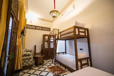 a bedroom with two bunk beds and a chandelier at Dar Layali Fez in Fès