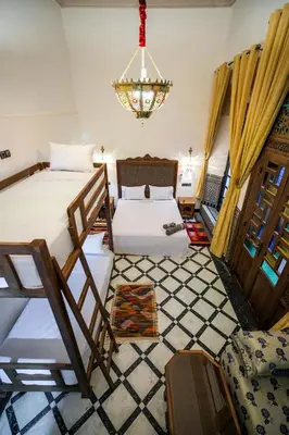 a bedroom with two beds and a chandelier at Dar Layali Fez in Fès