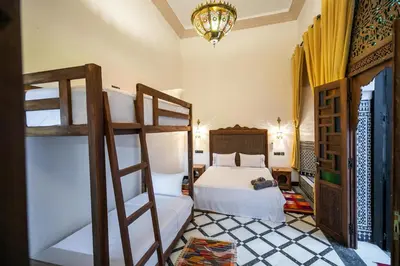 a bedroom with a bed and two bunk beds at Dar Layali Fez in Fès