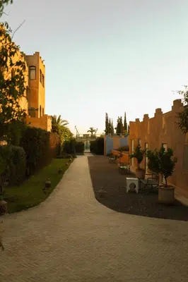 a brick walkway leading to a building with a park at Jenan Mayshad Marrakech, Luxurious Private Domaine with Pool and Padel Court in Marrakech