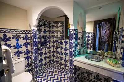 a bathroom with blue and white tiled walls and a sink at Riad Sidrat Fes in Fès