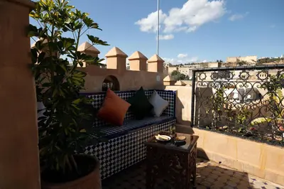 a balcony with a blue couch with pillows on it at Riad Sidrat Fes in Fès