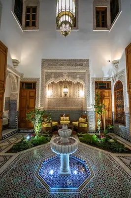 a lobby with a fountain in the middle of a building at Riad Sidrat Fes in Fès