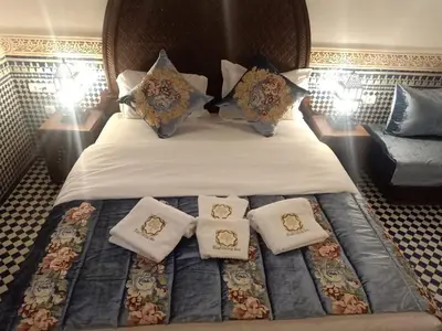 a bedroom with a bed with pillows on it at Riad Sidrat Fes in Fès