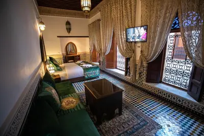 a bedroom with a bed and a tv in a room at Riad Sidrat Fes in Fès