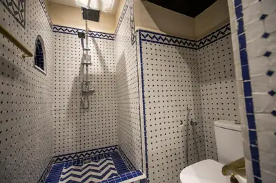 a bathroom with a shower with blue and white tiles at Riad Sidrat Fes in Fès