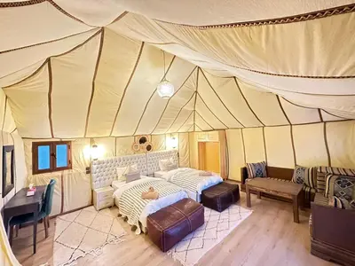a living room with a couch in a tent at Nomads Dunes Nest in Merzouga