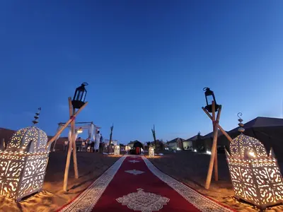 a road in the desert at night with lights at Nomads Dunes Nest in Merzouga