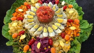 a plate of vegetables and fruit on a table at Riad Assia Foum Zguid in Foum Zguid