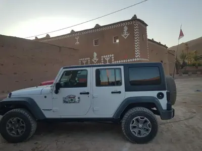 a white jeep parked in front of a building at Riad Assia Foum Zguid in Foum Zguid