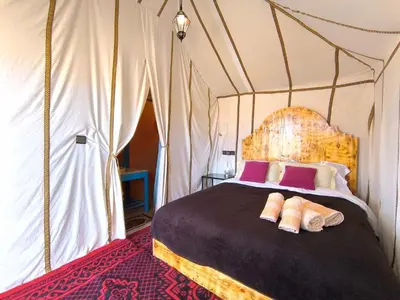 a bedroom with a bed in a tent at Luxury Bega Camp in Merzouga