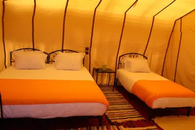 a room with two beds in a tent at Luxury Bega Camp in Merzouga