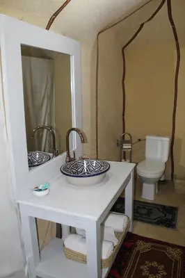 a bathroom with two sinks and a mirror at Luxury Bega Camp in Merzouga