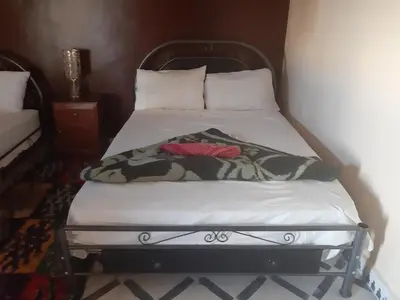 a bed with two pillows on it in a room at Guests House in Merzouga