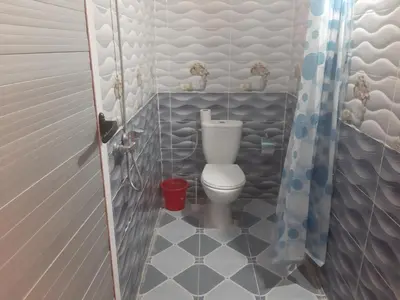 a small bathroom with a toilet in a stall at Guests House in Merzouga