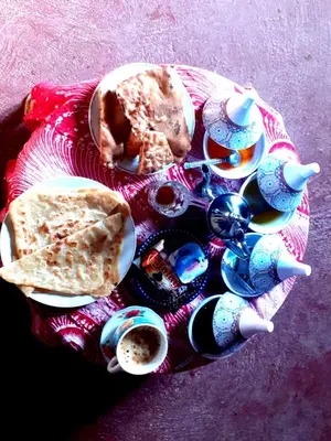 a plate of food and drinks on a table at Guests House in Merzouga