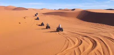a group of people riding motorcycles in the desert at Guests House in Merzouga