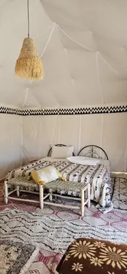 a bedroom with a bed in a tent at Sun Bivouac Chegaga in El Gouera