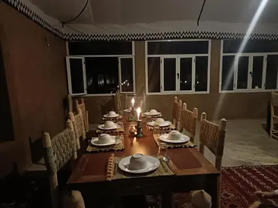 a long wooden table with plates and candles on it at Sun Bivouac Chegaga in El Gouera
