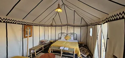 a bedroom with a bed in a tent at Sun Bivouac Chegaga in El Gouera