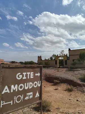 a sign in the middle of a desert with buildings at Gite Amoudou in Ouarzazate