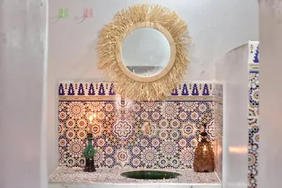 a mirror on a tiled wall with a sink at Camp Ayour Mhamid in Mhamid