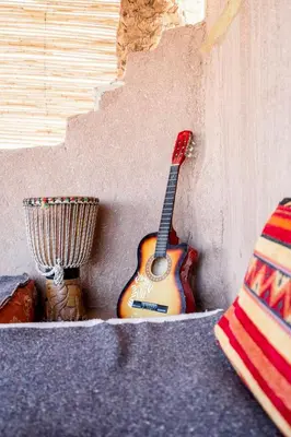 a guitar is leaning against a wall at Camp Ayour Mhamid in Mhamid