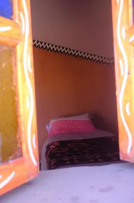 a small bed in a room with a wooden frame at Camp Ayour Mhamid in Mhamid