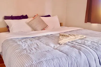 a bed with two pillows and a towel on it at Camp Ayour Mhamid in Mhamid