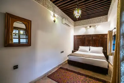 a bedroom with a bed and a mirror on the wall at Riad Fes Aicha & SPA in Fès