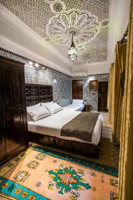 a bedroom with a bed in a room with a ceiling at Riad Fes Aicha & SPA in Fès