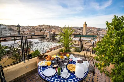 a table with food on a balcony with a view at Riad Fes Aicha & SPA in Fès