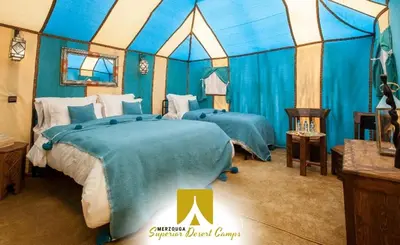 a bedroom with two beds in a tent at Superior Desert Camp in Merzouga