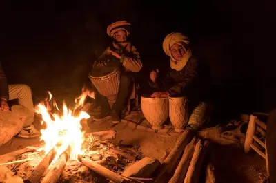 a group of people sitting around a fire at Superior Desert Camp in Merzouga