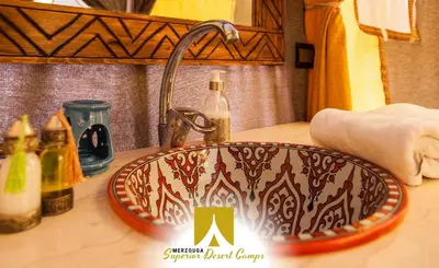 a bathroom counter with a sink with a faucet at Superior Desert Camp in Merzouga