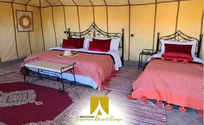 a bedroom with two beds in a tent at Superior Desert Camp in Merzouga