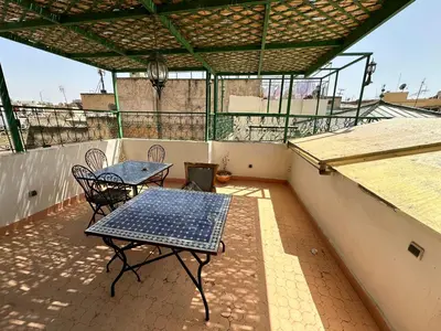 a patio with a table and chairs on a balcony at Riad Shama Fes in Fès
