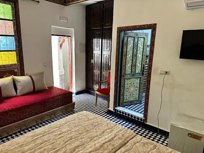 a living room with a mirror and a red couch at Riad Shama Fes in Fès