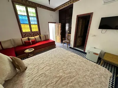 a living room with a large bed and a couch at Riad Shama Fes in Fès