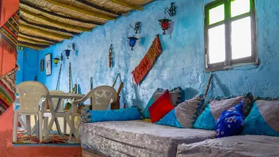 a blue room with a couch with pillows and a table at Gîte Forest Tagroumte in Azrou